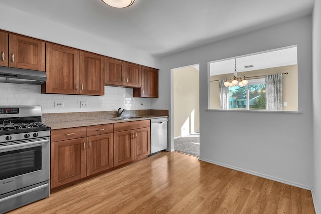 143 W Fabish Dr Unit 143, Buffalo Grove, IL 60089 - kitchen featuring stainless steel appliances, range hood, light wood finished floors, a chandelier, and backsplash