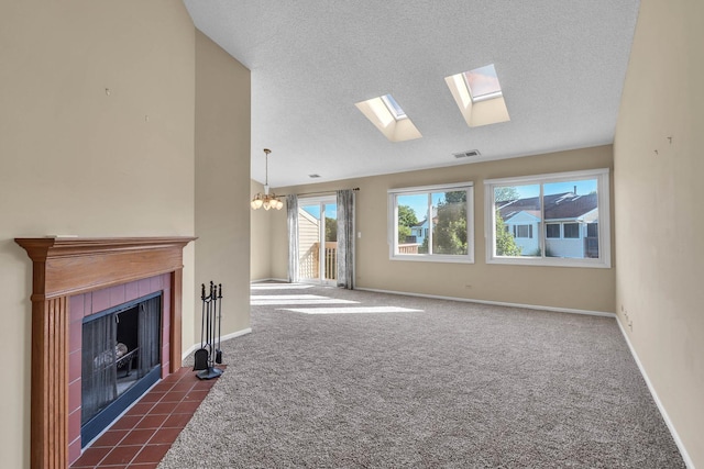 143 W Fabish Dr Unit 143, Buffalo Grove, IL 60089 - unfurnished living room with lofted ceiling, a tile fireplace, a skylight, a textured ceiling, and dark carpet