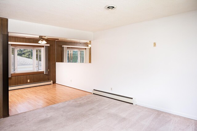 207 Muehl Dr, Lockport, IL 60441 - empty room featuring a baseboard heating unit, plenty of natural light, carpet flooring, and wood walls