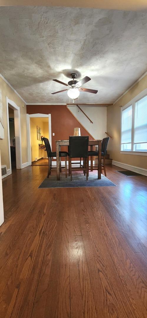1605 S 16th Ave, Maywood, IL 60153 - dining room with dark wood-style floors, ceiling fan, crown molding, and baseboards