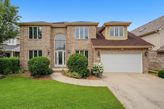 view of front of house with a front lawn, a garage, driveway, and brick siding