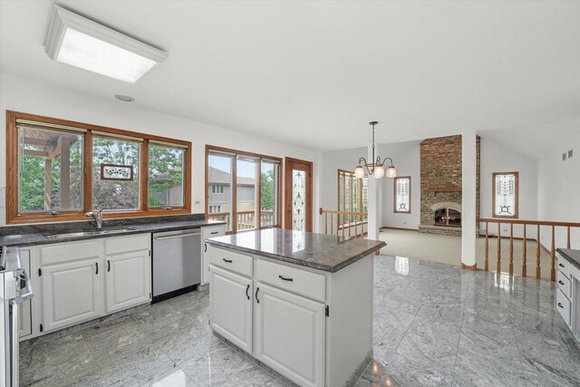 kitchen featuring stainless steel dishwasher, healthy amount of natural light, a center island, and white cabinets