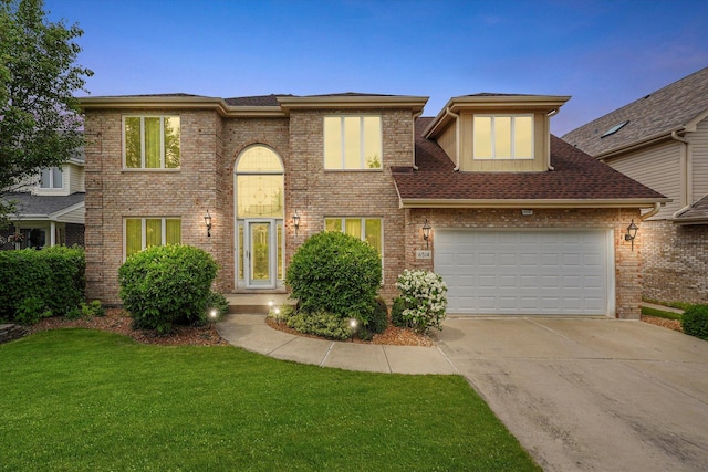 traditional-style home with driveway, a front lawn, a garage, and brick siding