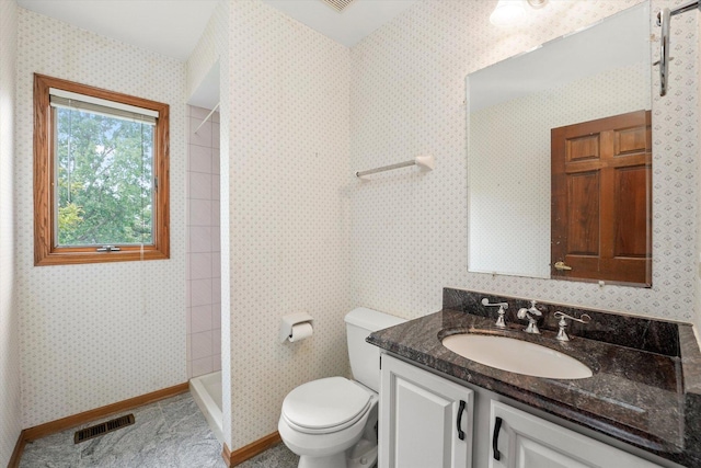 full bathroom featuring a tile shower and vanity