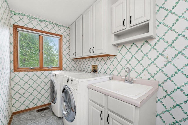 laundry room with cabinet space, washing machine and clothes dryer, and wallpapered walls