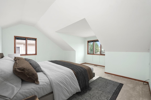 bedroom featuring light colored carpet and lofted ceiling