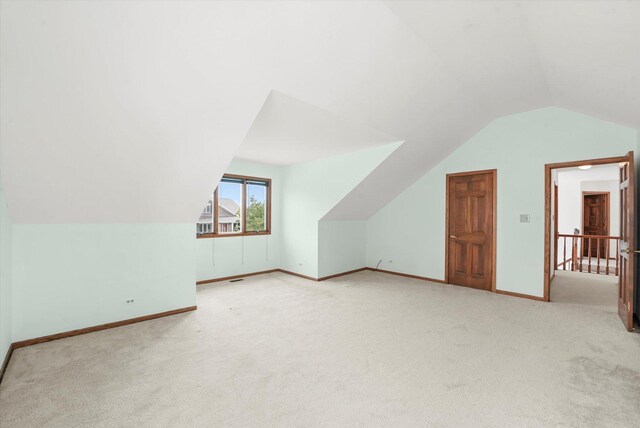 additional living space with lofted ceiling and carpet