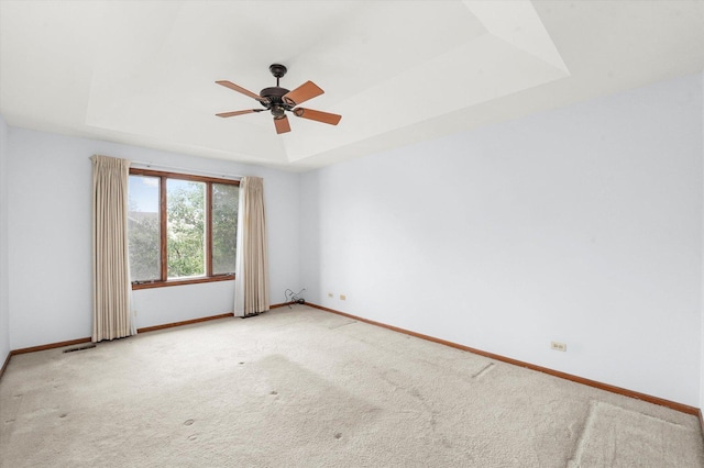 unfurnished room with carpet, ceiling fan, and a raised ceiling