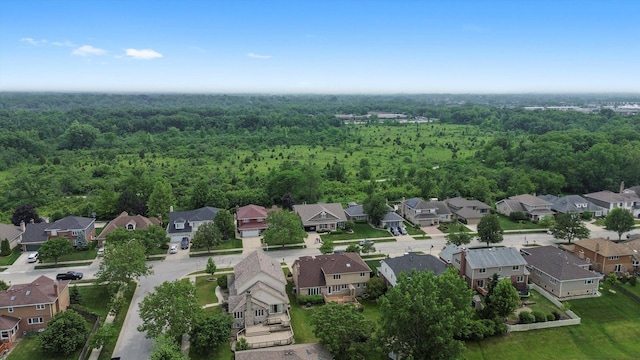view of property location featuring nearby suburban area and a forest