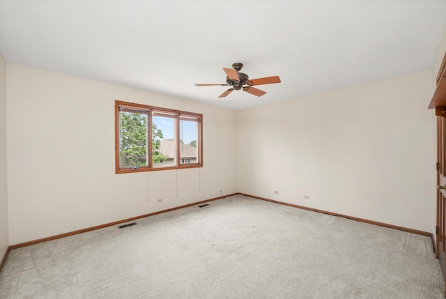 unfurnished room with light colored carpet and a ceiling fan