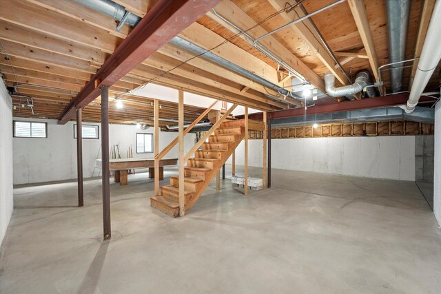 unfinished basement with heating unit, stairway, billiards table, and water heater