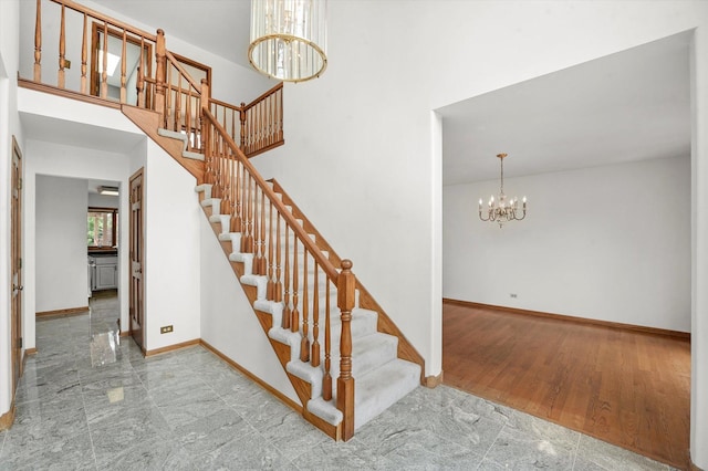 stairs featuring a chandelier and baseboards