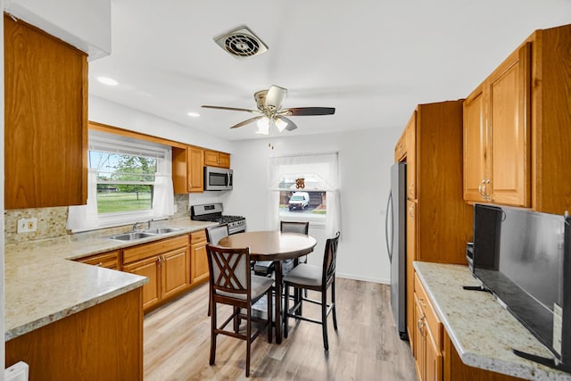 805 Highland Ave, Thornton, IL 60476 - kitchen featuring stainless steel appliances, a sink, a ceiling fan, light wood-type flooring, and brown cabinets