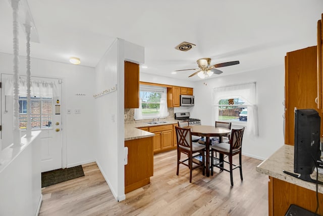 805 Highland Ave, Thornton, IL 60476 - kitchen with stainless steel appliances, a sink, light wood-style floors, a ceiling fan, and tasteful backsplash