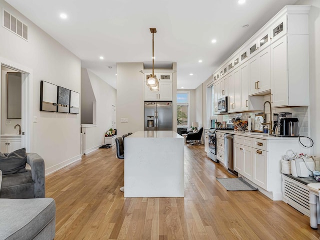 1707 S Jefferson St Unit 1, Chicago, IL 60616 - kitchen featuring appliances with stainless steel finishes, a sink, open floor plan, a center island, and light countertops