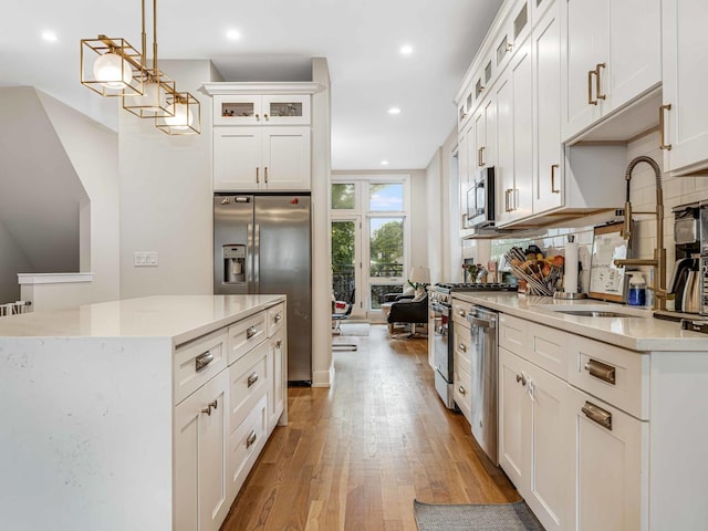 1707 S Jefferson St Unit 1, Chicago, IL 60616 - kitchen with stainless steel appliances, a sink, wood finished floors, recessed lighting, and decorative light fixtures