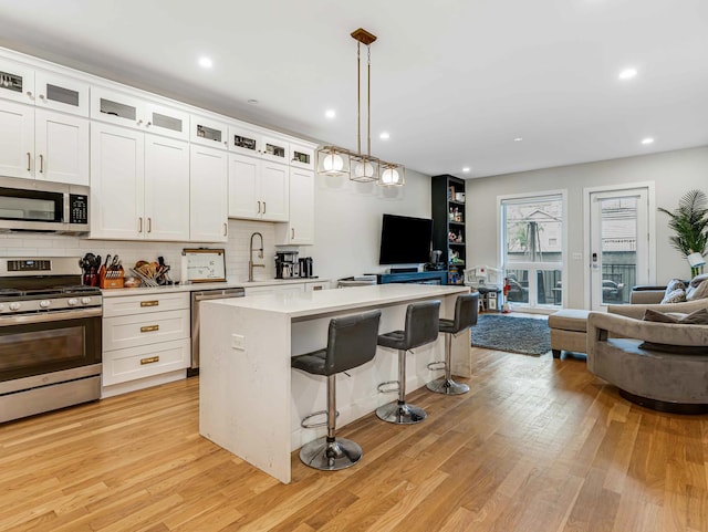 1707 S Jefferson St Unit 1, Chicago, IL 60616 - kitchen with appliances with stainless steel finishes, open floor plan, light wood-style flooring, light countertops, and recessed lighting