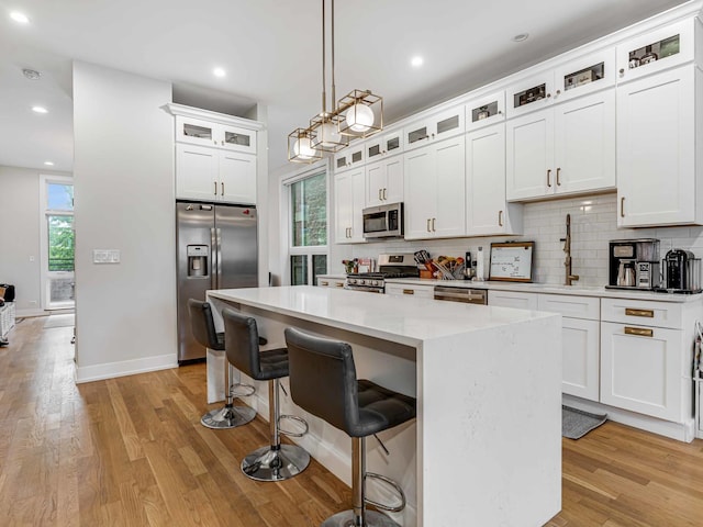 1707 S Jefferson St Unit 1, Chicago, IL 60616 - kitchen featuring stainless steel appliances, a center island, backsplash, light wood-style flooring, and recessed lighting