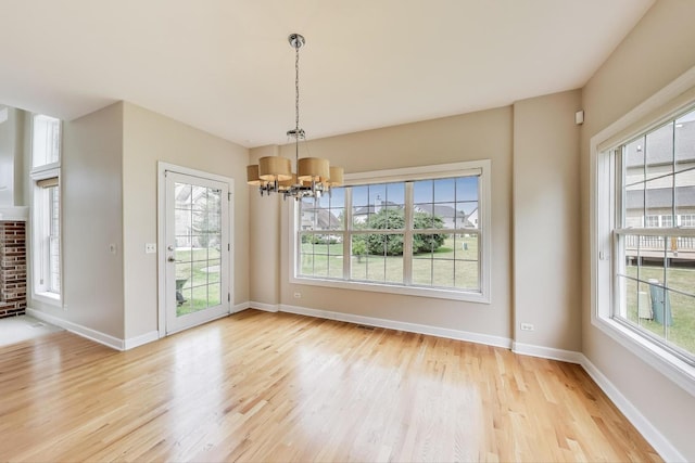 12354 S Blue Water Pkwy, Plainfield, IL 60585 - unfurnished dining area with healthy amount of natural light, light wood-style flooring, and a chandelier