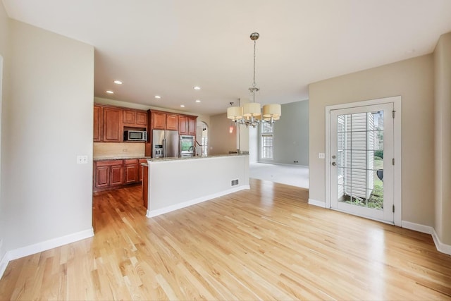 12354 S Blue Water Pkwy, Plainfield, IL 60585 - kitchen featuring stainless steel appliances, a chandelier, light wood-style flooring, hanging light fixtures, and light countertops