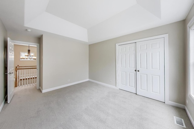 12354 S Blue Water Pkwy, Plainfield, IL 60585 - unfurnished bedroom featuring carpet flooring, a chandelier, a tray ceiling, and a closet