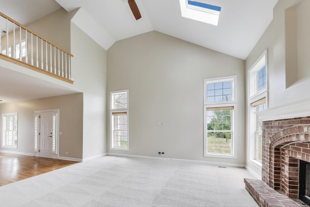 12354 S Blue Water Pkwy, Plainfield, IL 60585 - unfurnished living room with high vaulted ceiling, carpet floors, a brick fireplace, a ceiling fan, and healthy amount of natural light