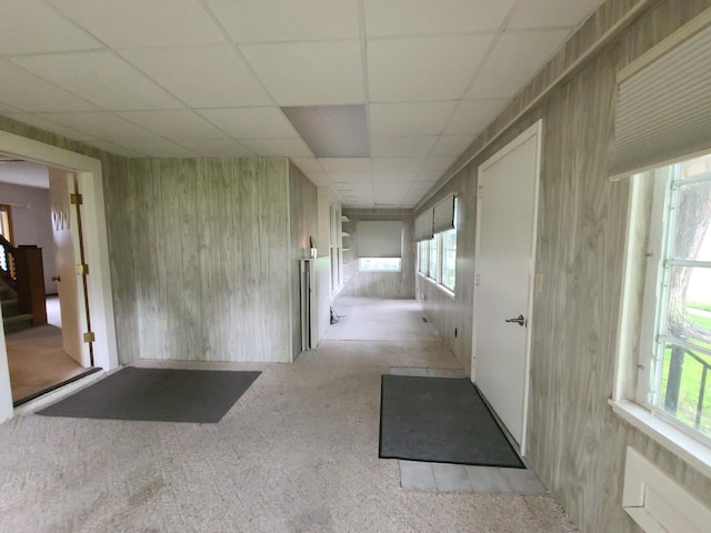 603 7th Ave, Sterling, IL 61081 - hallway featuring carpet flooring, a paneled ceiling, stairs, and wood walls