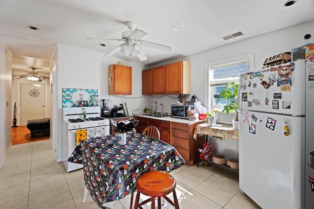 4512 S Fairfield Ave, Chicago, IL 60632 - kitchen with white appliances, a ceiling fan, light tile patterned flooring, brown cabinetry, and a sink