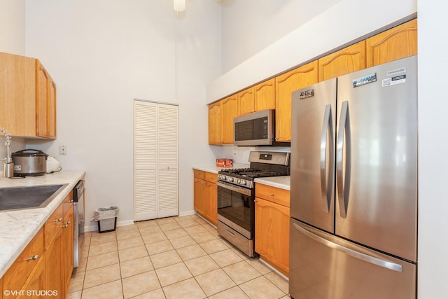 736 N Gary Ave Unit 208, Carol Stream, IL 60188 - kitchen with stainless steel appliances, a high ceiling, light countertops, light tile patterned floors, and baseboards