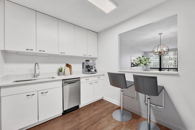 1636 N Wells St Unit 1503, Chicago, IL 60614 - kitchen featuring stainless steel dishwasher, a sink, wood finished floors, light countertops, and white cabinetry