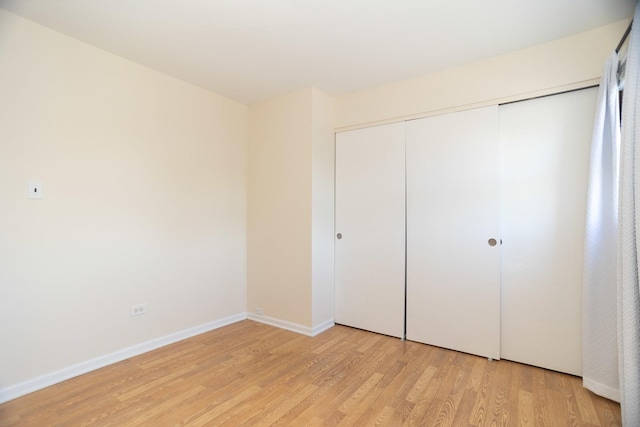 7930 164th Ct Unit 253, Tinley Park, IL 60477 - unfurnished bedroom featuring light wood-type flooring, a closet, and baseboards