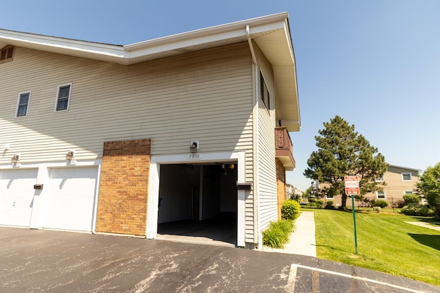 7930 164th Ct Unit 253, Tinley Park, IL 60477 - view of home's exterior featuring a garage, a yard, asphalt driveway, and brick siding