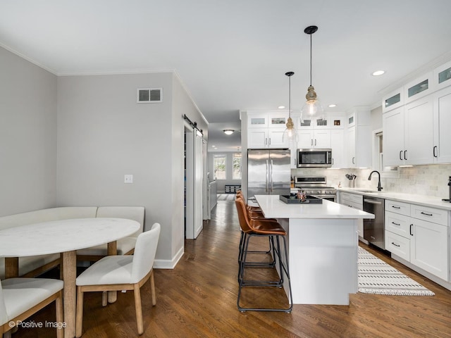 1043 W Wolfram St Unit 1, Chicago, IL 60657 - kitchen featuring appliances with stainless steel finishes, a barn door, a sink, tasteful backsplash, and dark wood finished floors