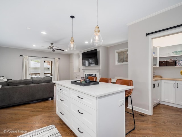 1043 W Wolfram St Unit 1, Chicago, IL 60657 - kitchen featuring open floor plan, recessed lighting, a kitchen breakfast bar, white cabinets, and dark wood finished floors