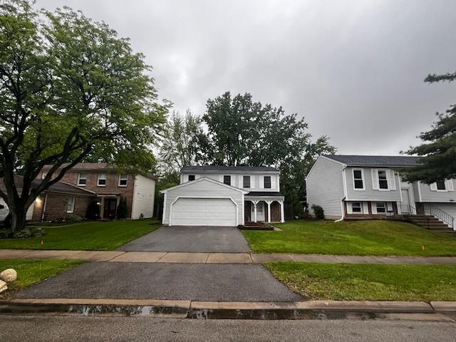 930 W Bryn Mawr Ave, Roselle, IL 60172 - view of front of home featuring driveway, a front lawn, and an attached garage