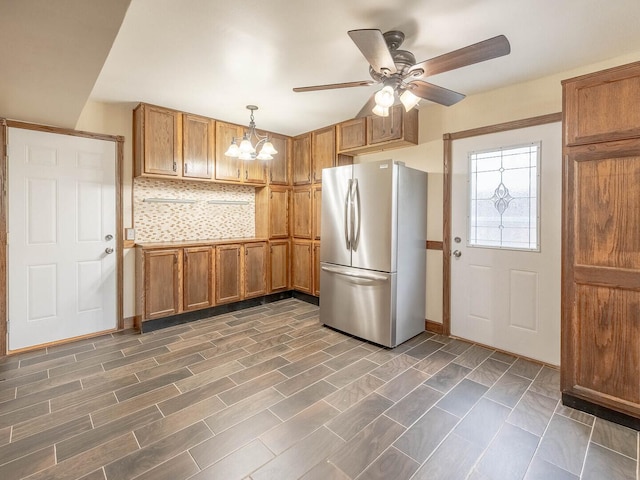 930 W Bryn Mawr Ave, Roselle, IL 60172 - kitchen with freestanding refrigerator, a ceiling fan, brown cabinets, and pendant lighting