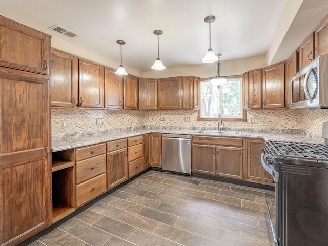 930 W Bryn Mawr Ave, Roselle, IL 60172 - kitchen featuring appliances with stainless steel finishes, a sink, backsplash, and hanging light fixtures