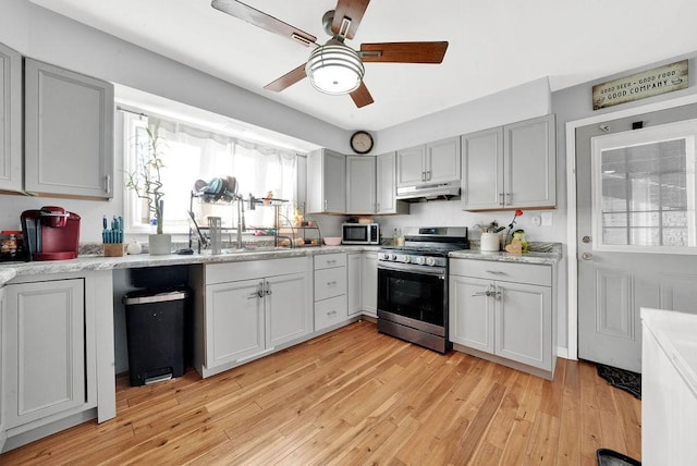 18006 Oakwood Ave, Lansing, IL 60438 - kitchen with appliances with stainless steel finishes, under cabinet range hood, a ceiling fan, light countertops, and light wood-style flooring