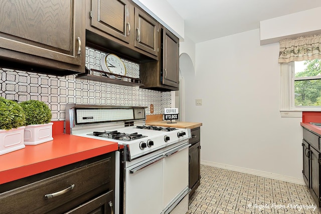 2618 Kashmiri Ave, Mchenry, IL 60050 - kitchen with gas range gas stove, decorative backsplash, dark brown cabinets, arched walkways, and baseboards