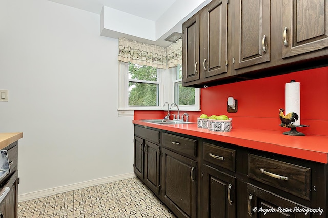 2618 Kashmiri Ave, Mchenry, IL 60050 - kitchen with a sink, baseboards, light countertops, and dark brown cabinets