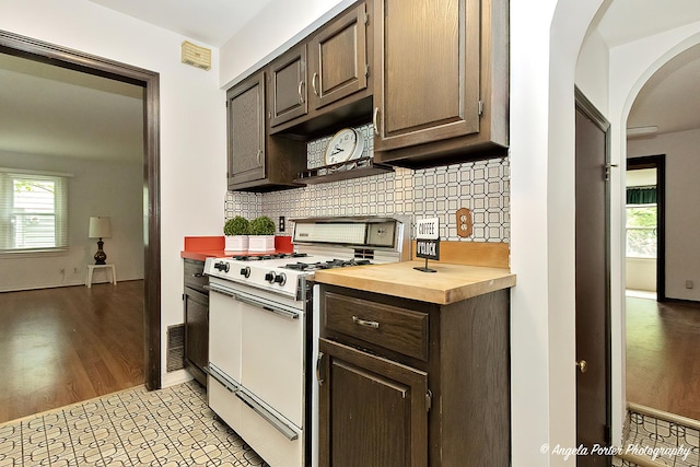 2618 Kashmiri Ave, Mchenry, IL 60050 - kitchen featuring gas range gas stove, arched walkways, butcher block counters, dark brown cabinetry, and tasteful backsplash