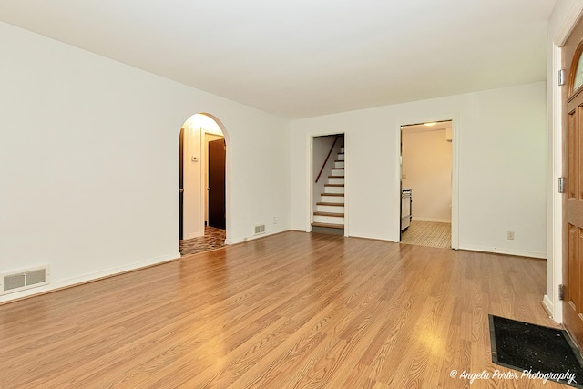 2618 Kashmiri Ave, Mchenry, IL 60050 - unfurnished room featuring stairs, arched walkways, light wood-type flooring, and baseboards
