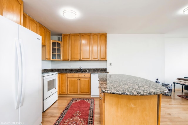 5415 N Sheridan Rd Unit 1504, Chicago, IL 60640 - kitchen with white appliances, light wood-type flooring, a sink, dark stone countertops, and glass insert cabinets
