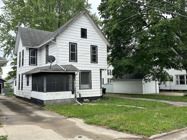 107 W S St, Morrison, IL 61270 - view of front facade with a shingled roof, an outbuilding, a front yard, and a sunroom