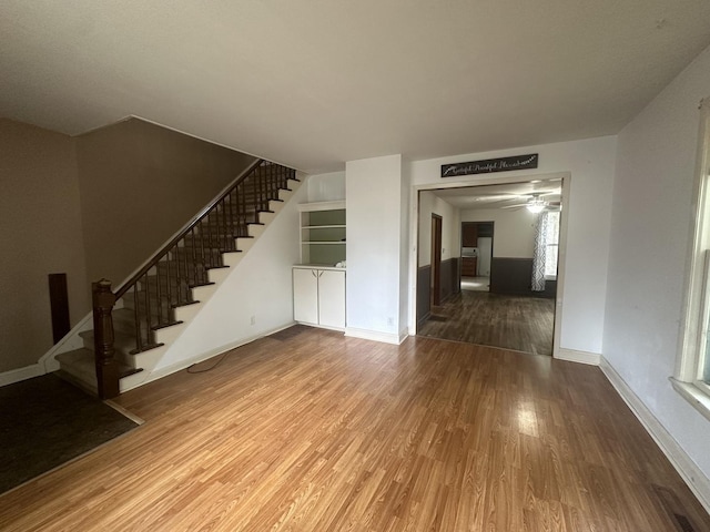 107 W S St, Morrison, IL 61270 - unfurnished living room featuring wood finished floors, stairs, baseboards, and ceiling fan