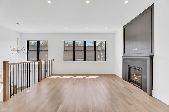 3905 N Drake Ave, Chicago, IL 60618 - unfurnished living room with a chandelier, light wood-type flooring, baseboards, recessed lighting, and a fireplace