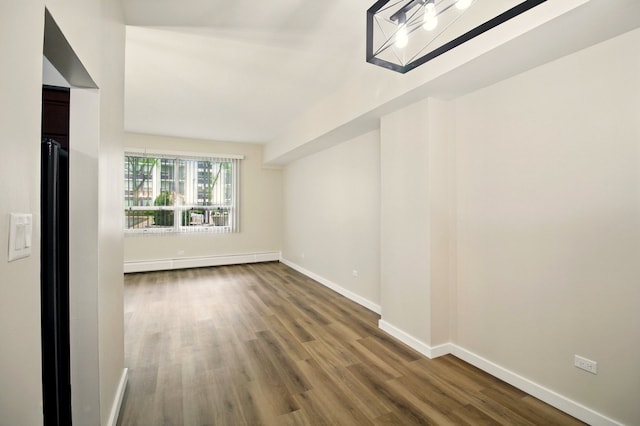 9009 Golf Rd Unit 1C, Des Plaines, IL 60016 - spare room with wood finished floors, baseboards, and a baseboard radiator
