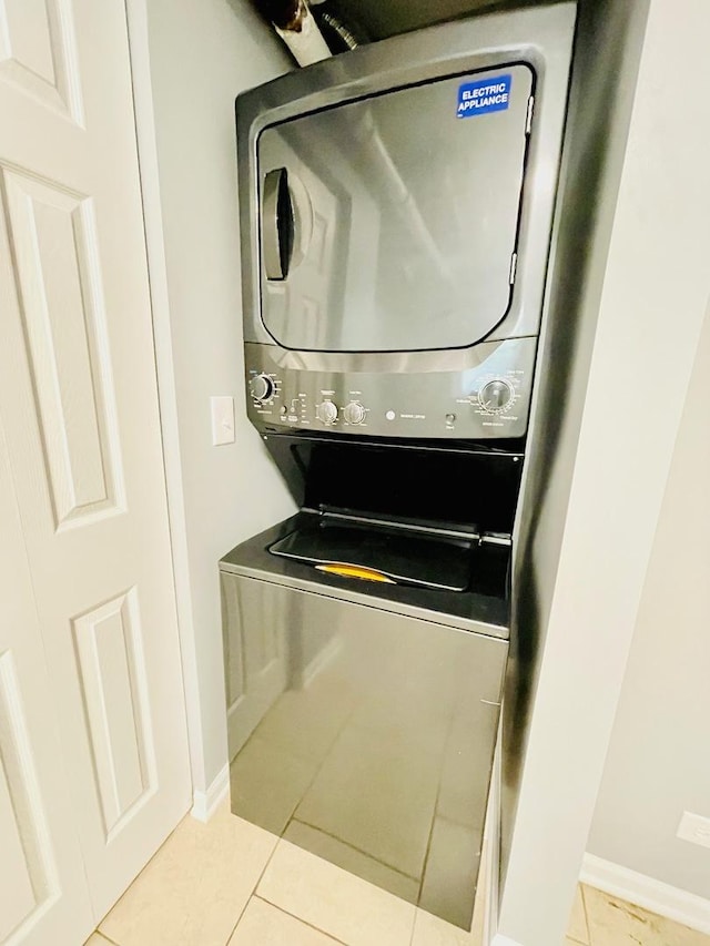 2300 W Granville Ave Unit G, Chicago, IL 60659 - laundry room featuring stacked washer / drying machine, tile patterned flooring, and baseboards