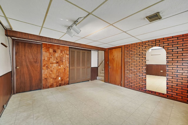8 E Eureka St, Lemont, IL 60439 - unfurnished room with brick wall, wooden walls, tile patterned floors, and stairs