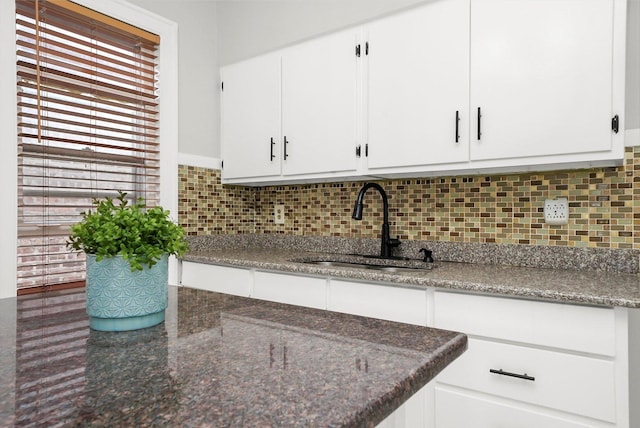 5331 W Schubert Ave, Chicago, IL 60639 - kitchen featuring white cabinetry, tasteful backsplash, and dark stone counters